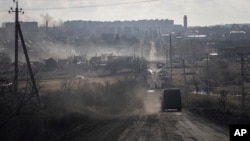 A Ukrainian police van drives on the highway for evacuation civilians in Khromove near Bakhmut, Ukraine, March 4, 2023.