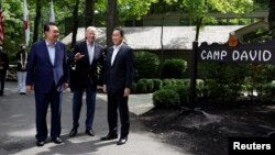 U.S. President Joe Biden greets Japanese Prime Minister Fumio Kishida, right, and South Korean President Yoon Suk Yeol during the trilateral summit Aug. 18, 2023, at Camp David near Thurmont, Md.
