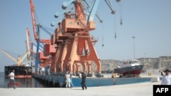 FILE - Laborers walk through the Gwadar, Pakistan, port on Oct. 4, 2017.
