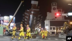 Firefighters complete their mission and evacuate from the collapsed building during a rescue operation following an earthquake in Hualien City, eastern Taiwan, April 3, 2024. 