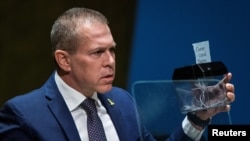 Israel's Ambassador to the U.N. Gilad Erdan shreds a piece of paper with the title of the United Nations Charter as he addresses delegates before voting on a draft resolution on Palestinian statehood, in New York, May 10, 2024.