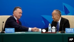 Australia's former Trade Minister Craig Emerson and China's former Foreign Minister Li Zhaoxing shake hands at the China-Australia High Level Dialogue in Beijing, Sept. 7, 2023. Australian Prime Minister Anthony Albanese's coming visit to China is a sign of improving relations. 