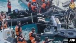 This frame grab from handout video taken on June 17, 2024 shows China coast guard personnel appearing to wield bladed weapons during an incident off Second Thomas Shoal. (Armed Forces of the Philippines - Public Affairs Office/ AFP) 
