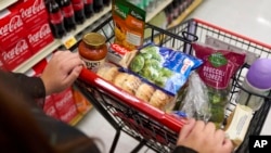 FILE - Jaqueline Benitez shops for groceries at a supermarket in Bellflower, Calif., Feb. 13, 2023. 