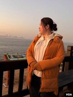 National Quemoy University student Wu Ching-hsuan watches the sunset on "Little Kinmen" island with her classmates on Jan. 17, 2024. (Elizabeth Lee/VOA)