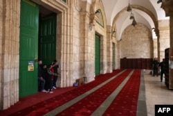 Palestinians stand inside the Al-Aqsa mosque as Israeli security forces watch at the Al-Aqsa mosque compound, also known as the Temple Mount complex to Jews, in Jerusalem on Apr. 9, 2023, during the Muslim holy fasting month of Ramadan