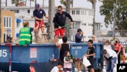 Long Beach lifeguards fill up sandbags for residents ahead of Hurricane Hilary in Long Beach, Calif., Aug. 19, 2023.