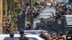 Anggota Kepolisian Pittsburgh bersiap untuk mengerahkan kendaraan lapis baja merespon penempakan yang terjadi di area Garfield, Pittsburgh, pada 23 Agustus 2023. (Foto: Benjamin B. Braun/Pittsburgh Post-Gazette via AP)