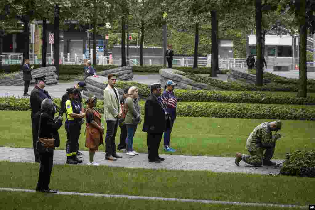 People pray before the commemoration ceremony on the 22nd anniversary of the September 11, 2001, terror attacks, in New York.