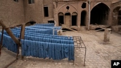Batches of freshly dyed thread for handwoven carpets dry in the sun at a workshop at the traditional bazaar of the city of Kashan, Iran, about 245 kilometers south of the capital, Tehran, April 30, 2024.