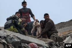 FILE - Emergency workers and volunteers pull a child from an apartment building hit by a Russian military strike during Russia's attack on Ukraine in Sloviansk, Donetsk region, Ukraine, April 14, 2023.