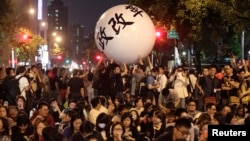 FILE - Activists push a ball reading "constitution reformation" during a sit-in to mark the one-year anniversary of the start of the Sunflower Movement outside the Legislative Yuan in Taipei, Taiwan, March 18, 2015.