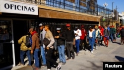 Migrantes de Venezuela que buscan asilo en EEUU hacen fila para obtener asesoramiento legal gratuito para acceder a la aplicación CBP One para solicitar una cita en un puerto de entrada terrestre al país, en el centro de Ciudad Juárez, México, 27 de enero de 2023 .