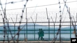 FILE - South Korean army soldiers patrol along the barbed-wire fence in Paju, South Korea, near the border with North Korea, Feb. 16, 2023. 