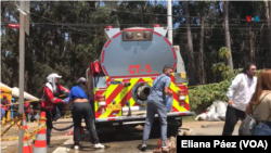Miembros de diferentes entidades gubernamentales y de ONGs, entregan botellas de agua a la comunidad afectada y a las personas que han aportado en apagar los incendios.