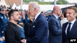 Президент США Джо Байден розмовляє з президентом України Володимиром Зеленським на початку міжнародної пам’ятної церемонії з нагоди 80-ї річниці висадки союзників у Нормандії, 6 червня. 2024. (Фото Людовіка МАРІНА / AFP)