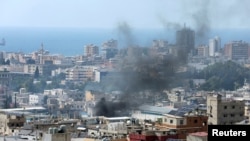 FILE - Smoke rises from Ein el-Hilweh Palestinian refugee camp during a previous round of Palestinian factional clashes, in Sidon, Lebanon, July 30, 2023.