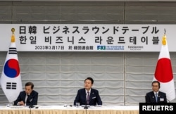 South Korea's President Yoon Suk Yeol joins Masakazu Tokura, chairman of Keidanen, the Japan Business Federation, and Kim Byong-joon, acting chairman of the Federation of Korean Industries, as they attend a Japan-Korea Business Roundtable meeting in Tokyo, Japan, March 17, 2023.