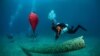 FILE - A diver inflates a lifting bag attached to remains of a fish farm on the seabed, near the island of Ithaca, Greece, June 10, 2021. (Cor Kuyvenhoven/Ghost Diving/Handout via Reuters) 
