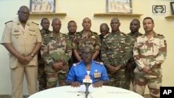 FILE - In this image taken from video provided by ORTN, Col. Maj. Amadou Abdramane, front center, makes a statement on July 26, 2023, in Niamey, Niger, as a delegation of military officers appeared on Niger State TV to announce their coup.
