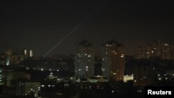 Ukrainian servicemen use a searchlight as they search for drones in the sky over the city during a Russian drone strike, amid Russia's attack on Ukraine, in Kyiv, Ukraine May 19, 2023.