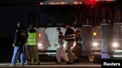 FILE - A Venezuelan migrant walks to board a repatriation flight as a part of an immigration enforcement process at the airport in Harlingen, Texas, Oct. 18, 2023.