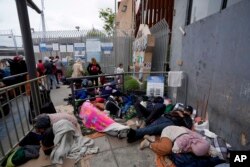 People waiting to apply for asylum camp near the pedestrian entrance to the San Isidro Port of Entry, linking Tijuana, Mexico with San Diego, June 1, 2023, in Tijuana, Mexico.