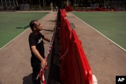 Richard Tsoi, former leader of now-disbanded Hong Kong Alliance in Support of Patriotic Democratic Movements of China, poses for photographs next to a closed pitch at Victoria Park in Hong Kong, Monday, May 29, 2023.