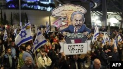 Protesters carry placards during a gathering called for by relatives of Israeli hostages held in Gaza since the October 7 attacks by Hamas militants, in Tel Aviv on March 9, 2024.