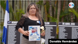Una madre nicaragüense sostiene el cartel de su hijo asesinado en una actividad en San José, Costa Rica. [Foto: Donaldo Hernández, VOA]