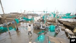 A man walks in floodwater after landfall of Cyclone Biparjoy at Jakhau in Kutch district of Western Indian state of Gujarat, India, June 17, 2023. 