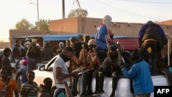 Des migrants sont assis à l'arrière d'un pick-up quelques minutes avant de se rendre à la frontière libyenne à Agadez, le 2 janvier 2024.