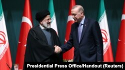 Turkey's President Tayyip Erdogan and Iran's President Ebrahim Raisi shake hands following a press conference in Ankara, Turkey, Jan. 24, 2024.
