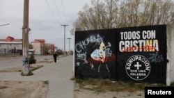 FILE - A person walks near a defaced painting of Argentina's Vice President Cristina Fernandez de Kirchner with the writing reading "All with Cristina" and "Thief, corrupt," in Rio Gallegos, Argentina October 10, 2023.