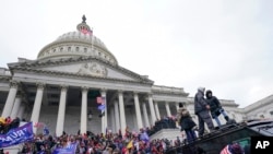 FILE - Rioters loyal to US President Donald Trump swarm the US Capitol in Washington, Jan. 6, 2021. 