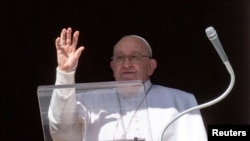 Pope Francis waves at the crowd, who are gathered on St Peter's Square during the Angelus prayer, from his window at the Vatican, Jan. 21, 2024. (Vatican Media/­Handout via Reuters)