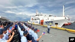 Personel Penjaga Pantai Filipina mengibarkan bendera Vietnam dan Filipina untuk menyambut kedatangan kapal Penjaga Pantai Vietnam (VCG), CSB 8002, di Manila, Filipina, Senin, 5 Agustus 2024. (Joeal Calupitan/AP)