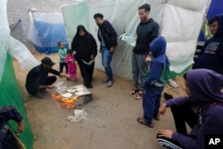 Palestinians displaced by the Israeli bombardment of the Gaza Strip cook near al Aqsa Hospital in Deir al Balah, Gaza Strip, Nov. 27, 2023.