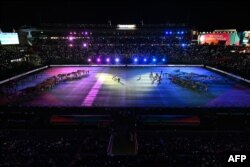 Para penampil membuat ular pelangi (kiri) dan whai (kanan), atau ikan pari, yang dirancang oleh seniman Maori dan First Nation, pada upacara pembukaan Piala Dunia Putri Australia dan Selandia Baru 2023 di Taman Eden di Auckland, 20 Juli 2023. (Saeed KHAN / AFP)