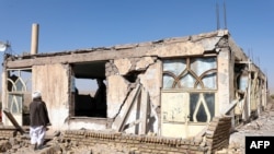 An Afghan man stands near a damaged house after the earthquakes in Sarbuland village, Zendeh Jan district of Herat province on Oct. 8, 2023. 