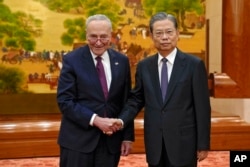 Visiting U.S. Senate Majority Leader Chuck Schumer, and Zhao Leji, chairman of China's National People's Congress pose for a photograph before their bilateral meeting at the Great Hall of the People in Beijing, Oct. 9, 2023.