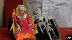 Dolls that were seized by authorities are displayed during a press conference to explain what they are made of at the Archeology Museum in Lima, Peru, Jan. 12, 2024.
