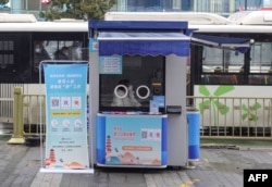 FILE - A staff member sits inside a job information booth that was transformed from a COVID-19 testing booth in Xian, in China's central Shaanxi province, Feb. 13, 2023.
