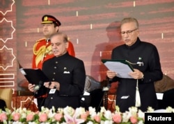 Pakistan's President Arif Alvi, right, administers the oath to Pakistan's newly elected Prime Minister Shehbaz Sharif, at the Presidential Palace in Islamabad, Pakistan, March 4, 2024. (Presidential Palace/Handout via Reuters)