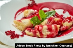 FILE - Ukrainian varenyky with cherries in a white plate of white tablecloth. (Adobe Stock Photo by Ismishko)