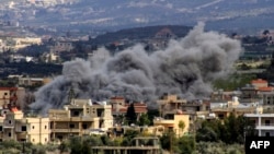 Smoke billows above buildings following an Israeli strike in the southern Lebanese border village of Majdal Zoun on March 9, 2024.