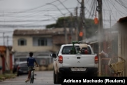 A truck sprays a street with insecticide to kill the Aedes aegypti mosquito. The effort is aimed at slowing a dengue outbreak in the Santa Maria neighborhood of Brasilia, Brazil, on January 23, 2024. (REUTERS/Adriano Machado)