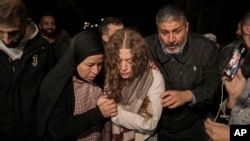 Palestinian activist Ahed Tamimi, center, is supported by her mother after she was released from prison by Israel, in the West Bank town of Ramallah, Nov. 30, 2023. A U.N. report on July 31, 2024, says prisoners and hostages of Israel and Hamas are subjected to mistreatment.