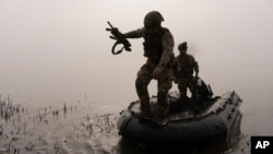 A Ukrainian serviceman jumps out of a boat onto the shore of the Dnipro River at the front line near Kherson, Ukraine, Oct. 15, 2023. Ukraine has reportedly gained a foothold on the eastern bank of the river.