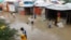 Somali children wade through floodwaters outside their makeshift shelters following heavy rains at the Al Hidaya camp for the internally displaced people on the outskirts of Mogadishu, Somalia, Nov. 6, 2023